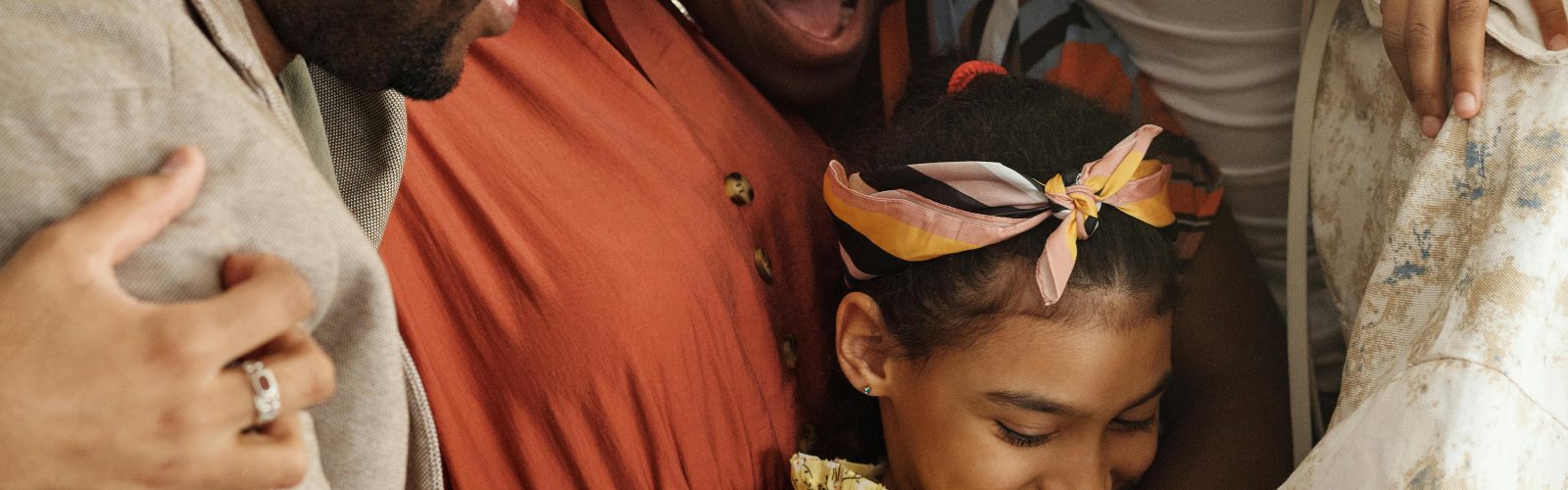An African American Family of various generations linked in embrace.