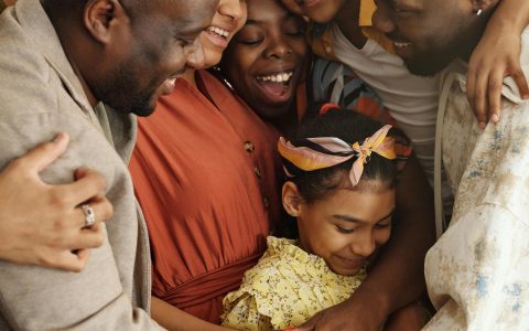 An African American Family of various generations linked in embrace.