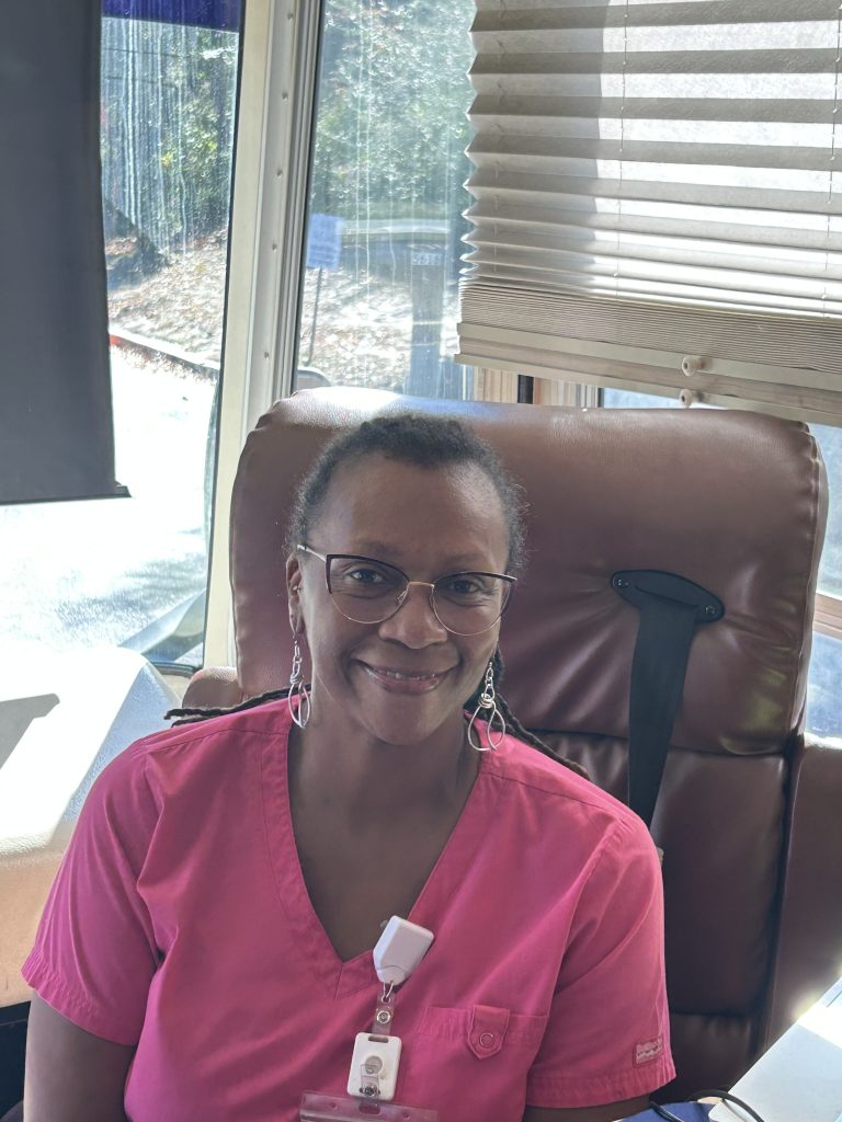 Image shows a picture of a Prisma Health Nurse on the Mobile Mammography team at Francis Burns United Methodist Church for their Mobile Mammography event held on November 11th, 2025. The nurse is a middle-aged Black woman with short, curly hair and pink nurse scrubs on.